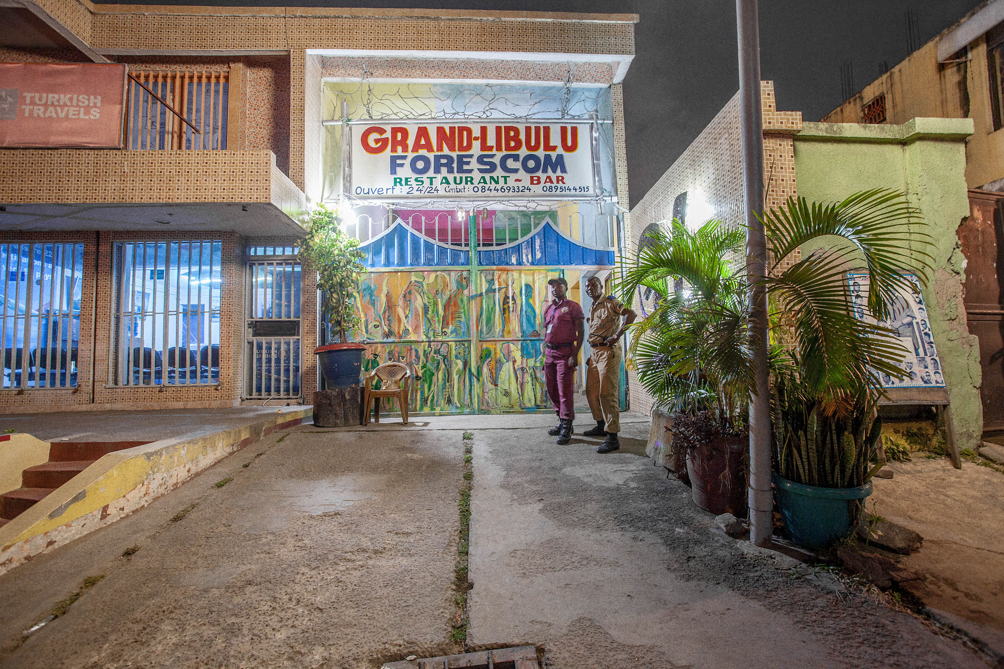 Two men standing outside a night club