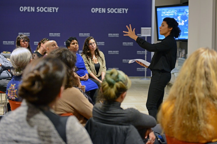 A woman stands in front of a crowd giving a presentation.