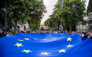 Many people carry a large European Union flag.