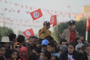 Boys waving flags in a crowd
