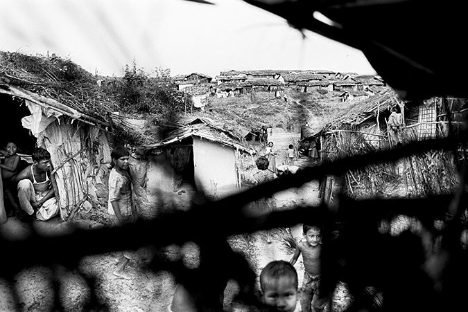 Makeshift camp viewed from behind a fence