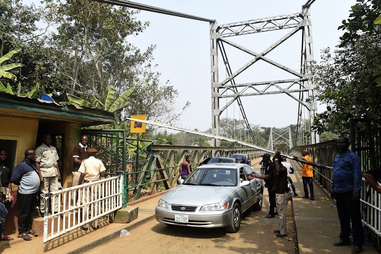 Security guards examine a vehicle at a checkpoint on the border between Cameroon and Nigeria in Mfum, Nigeria, on February 1, 2018. Photo credit: © Pius Utomi Ekpei/AFP/Getty A car driving over a bridge