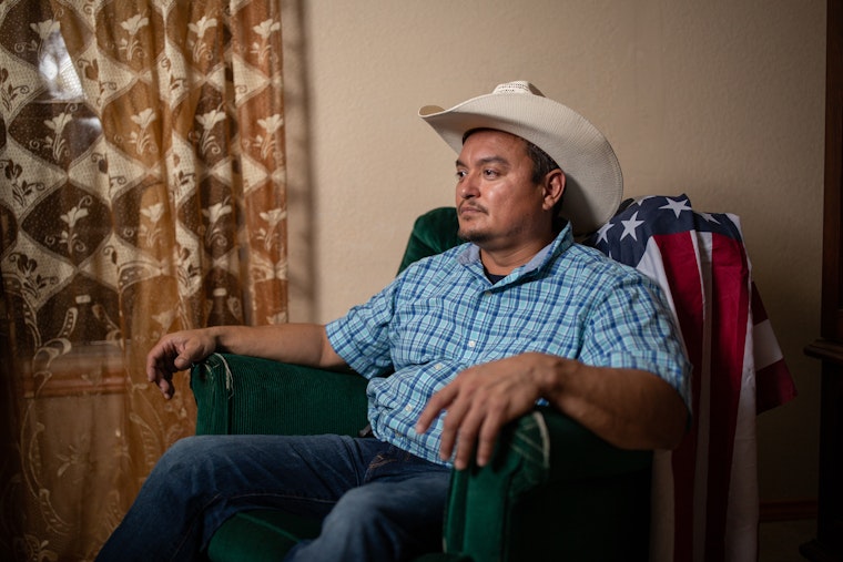 A man in a cowboy hat sitting in an armchair