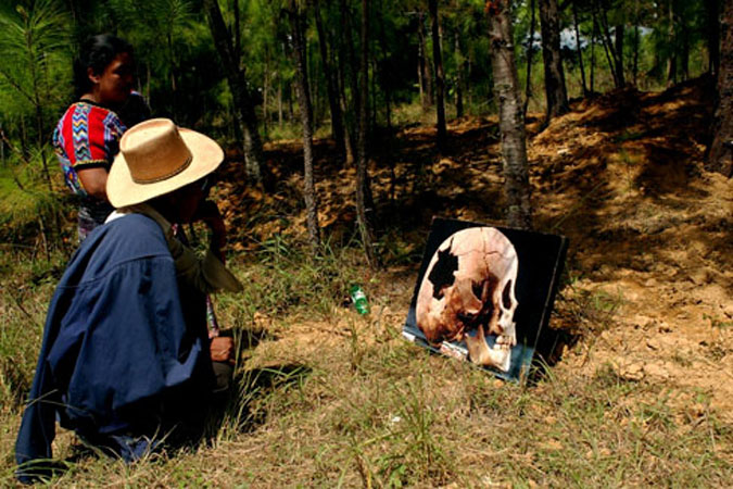 A man and woman look at a photo of a victim killed by army.