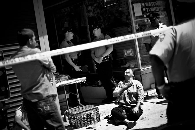 Woman sitting on the ground crying.