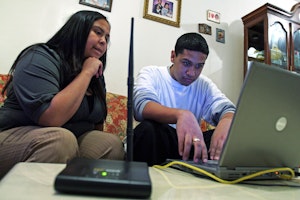 Two people in front of a laptop computer