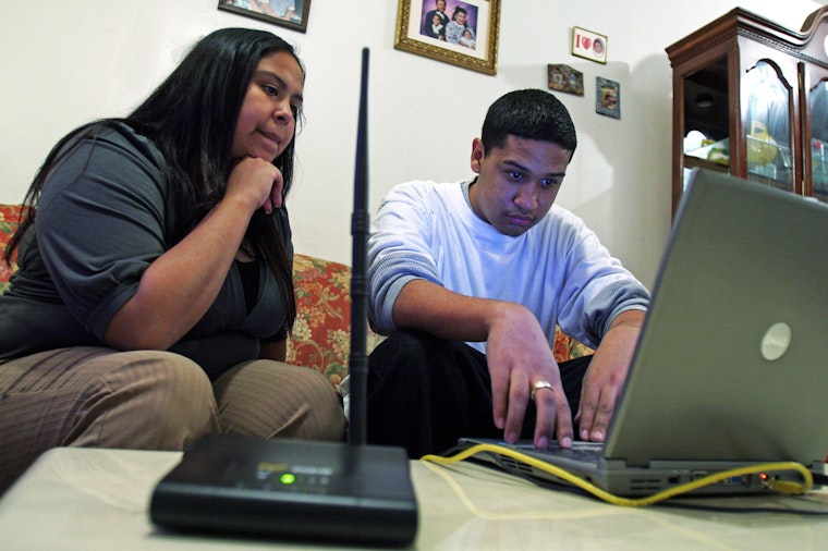 A young woman and her brother use Philadelphia’s municipal wireless project to log on to the internet on February 26, 2008. Photo credit: © Jessica Kourkounis/NYTimes/Redux Two people in front of a laptop computer