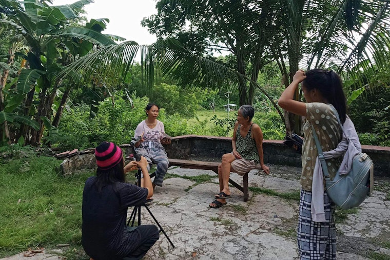 A group of people interview and film an elder.