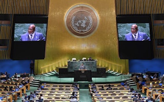 UN General Assembly, President Dennis Francis, speaking at the UN headquarters with his face appearing on two large screens behind him.