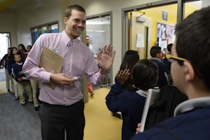 Teacher with his palm up in front of a line of students