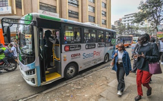 An electric bus picks up passengers.