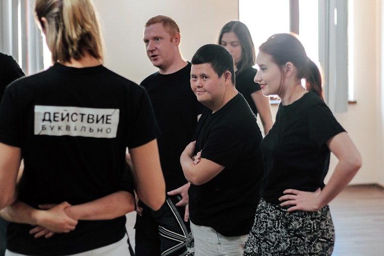 Members of a theater group wearing black shirts at a rehearsal