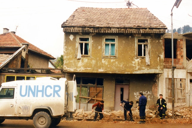 A UNHCR truck next to workers digging a trench