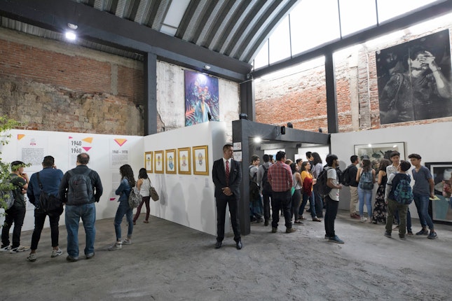 People and art work in a warehouse gallery space