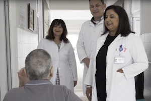 Doctors speaking with a patient in a hospital hallway