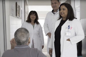 Still image from Roma Health Scholarship: 10 Years. First established in 2008, the Roma Health Scholarships Program was intended to support young Roma trying to ensure their communities got the health care they deserved. More than a decade later, there’s no doubt it worked. Doctors speaking with a patient in a hospital hallway