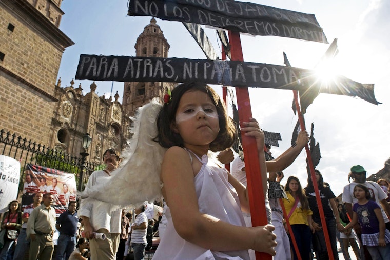 A young girl dressed as an angel at a rally