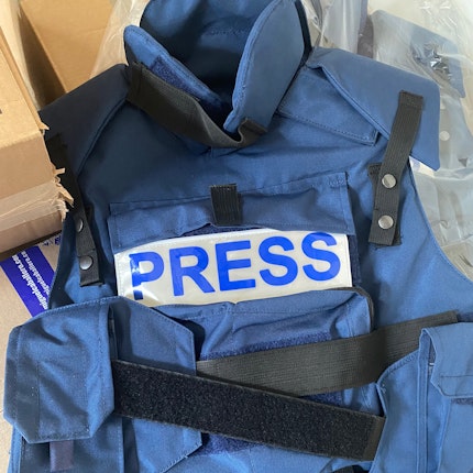 A flack jacket that says PRESS