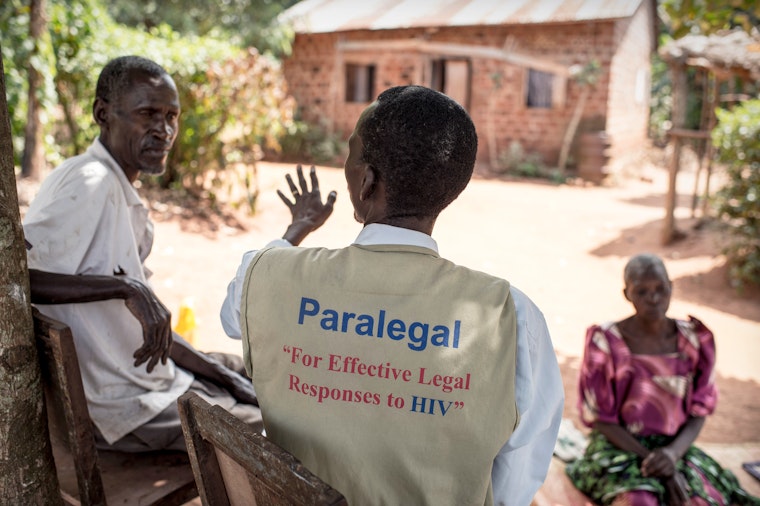 Paralegal talking with a family in Uganda