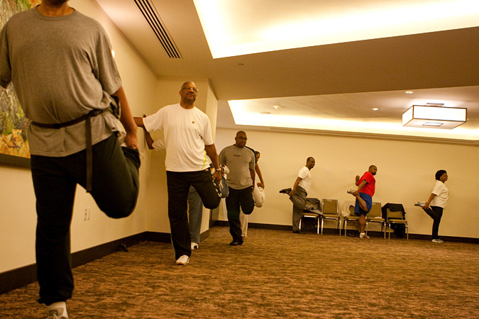 People stretching legs, doing qi-gong in a room