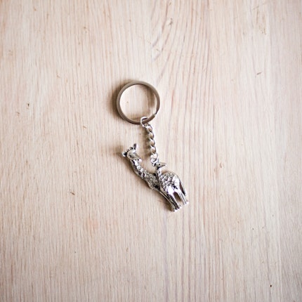 A silver giraffe keychain on a table