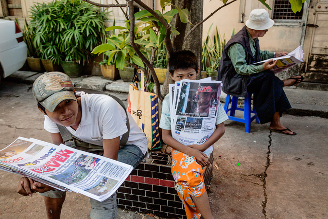 Boys sitting with newspapers