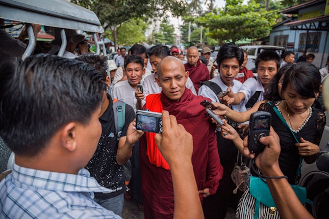 A monk walks through crowd