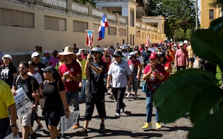 People march with Puerto Rican flags.