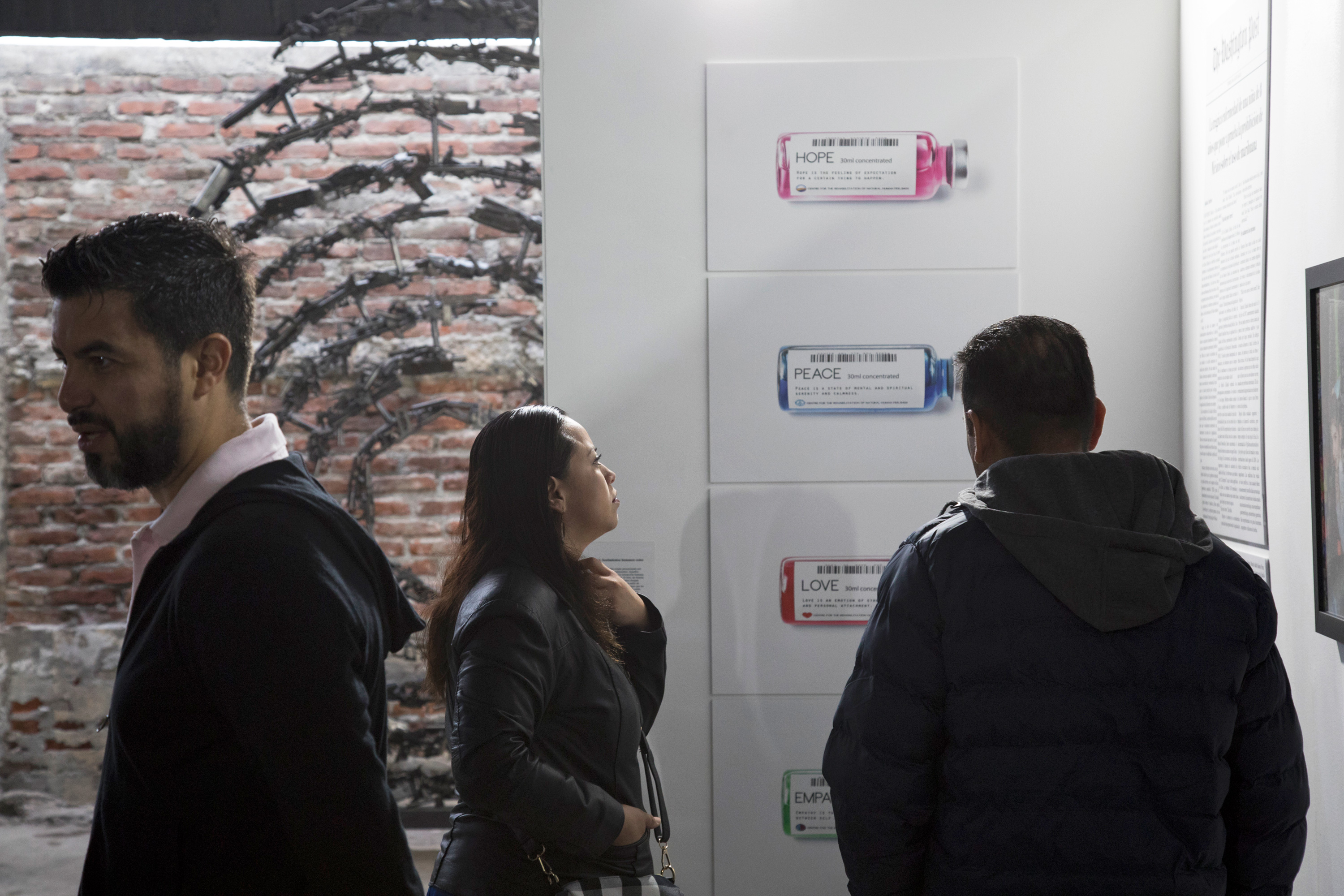 People looking at art work of medicine vials