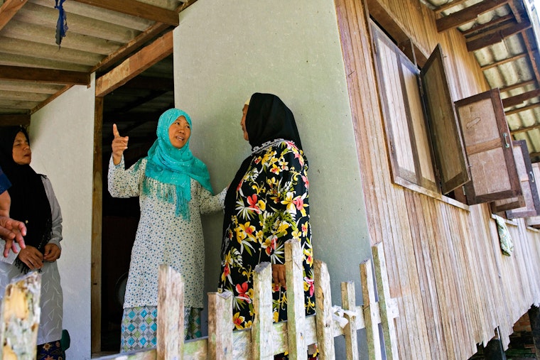 Women talking on the porch of a home