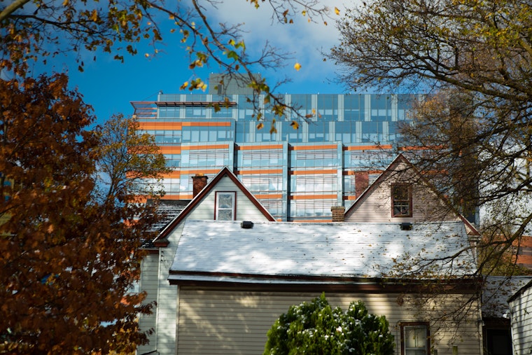 A high-rise medical building seen behind residential homes