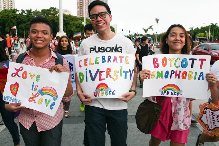 Three people holding signs