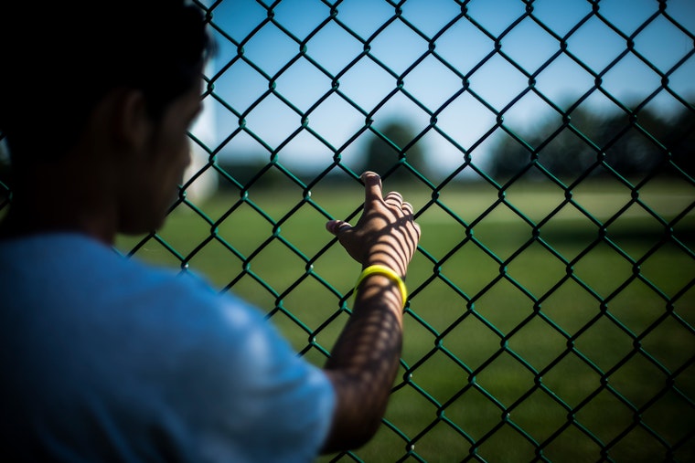 A hand on a chain link fence