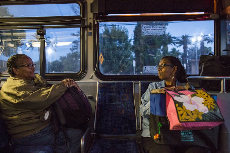 Two women sitting on a bus at dawn
