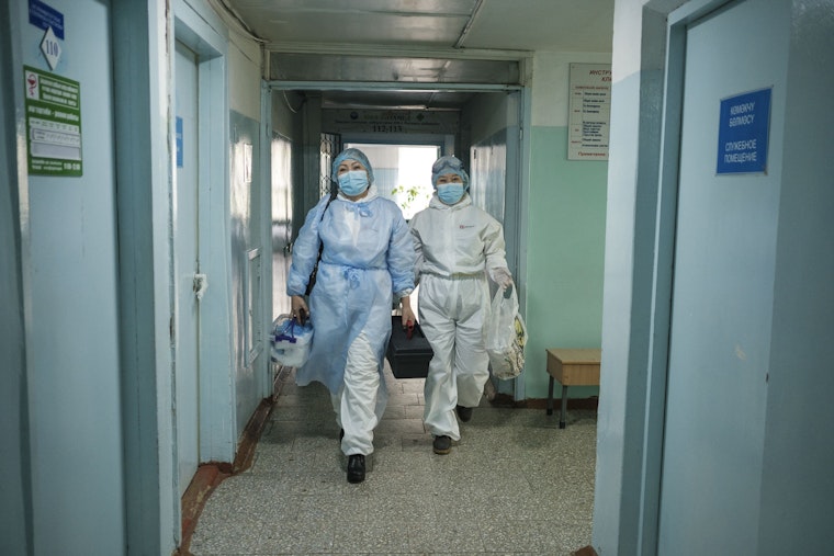 Dois médicos caminhando em um corredor.