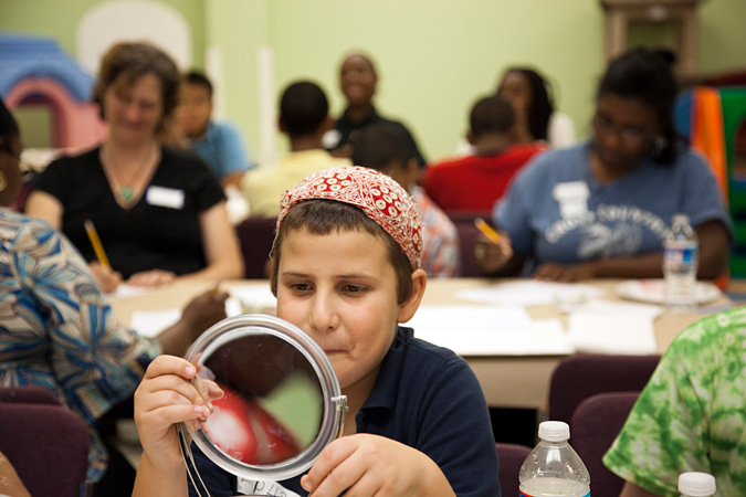 Child sitting at a desk with a mirror