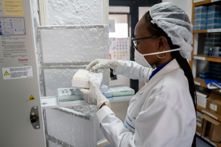A laboratory technician removes samples from a freezer, in Dakar, Senegal, on April 9, 2020. Photo credit: © Sylvain Cherkaoui/Panos/Redux A laboratory tech holds a box of virus samples