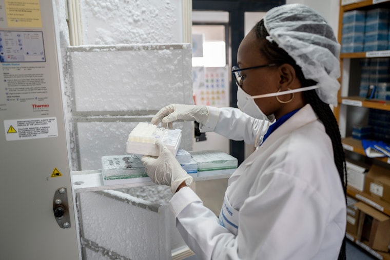 Um técnico de laboratório segura uma caixa com amostras de vírus.