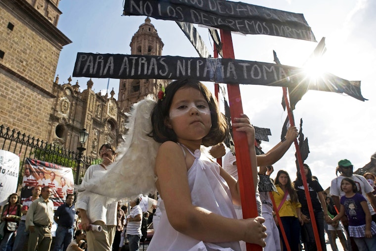 A young girl dressed as an angel takes part in an antiviolence rally in Morelia, Mexico on June 4, 2011. Photo credit: © Porfirio Gonzalez/Getty A young girl dressed as an angel looks at the camera during an antiviolence rally in Morelia, Mexico.