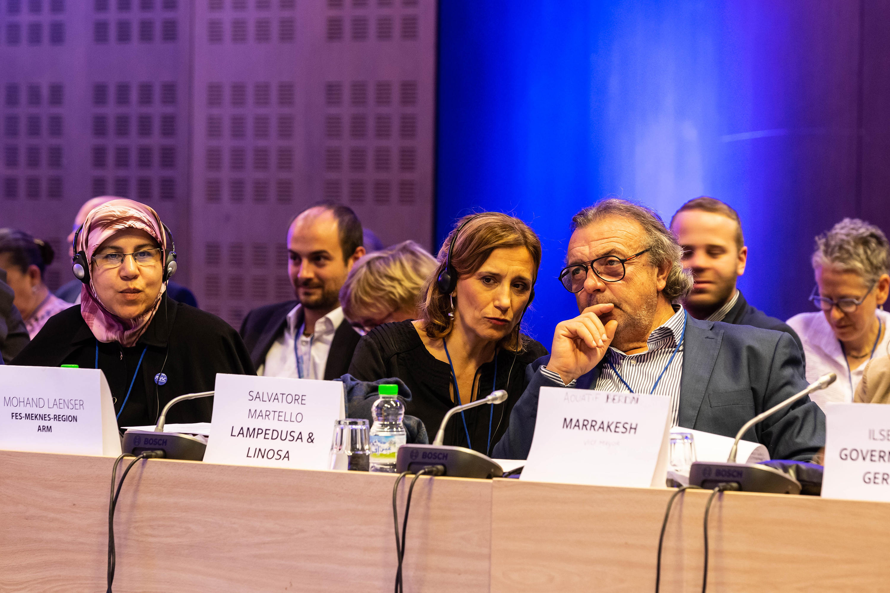 A group of mayors sitting behind a table with microphones.