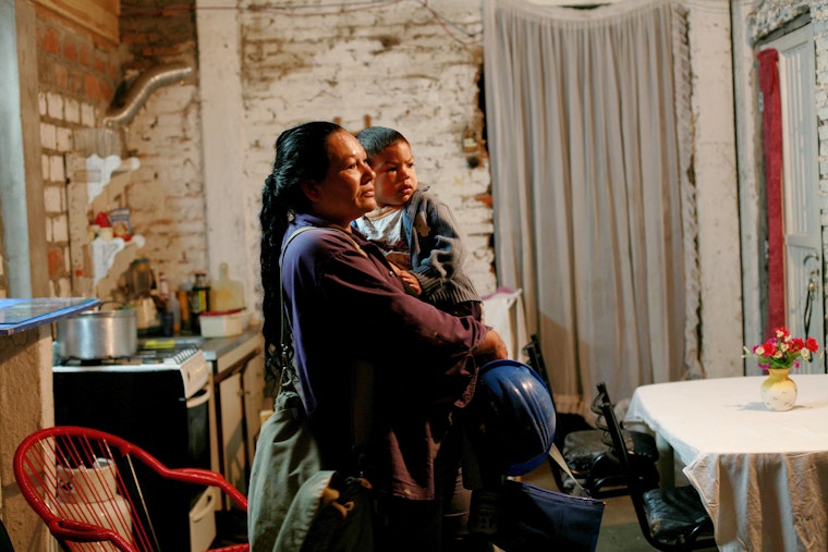 A mother holds her daughter as she prepares to take her to day care, in Argentina, on April 15, 2009. Photo credit: © Marta Nascimento/REA/Redux A woman holding her daughter