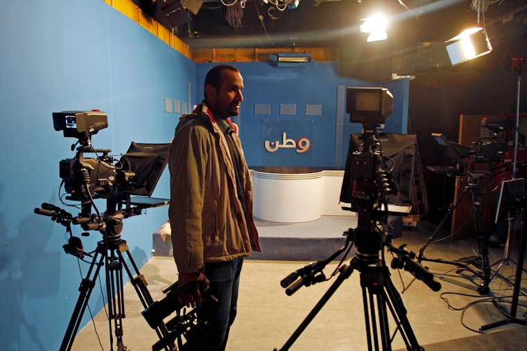 A Palestinian cameraman from Wattan stands in the station’s studio in the West Bank city of Ramallah on February 29, 2012. Photo credit: © Mohamad Torokman/Reuters/Newscom A man stands in a television studio holding a camera