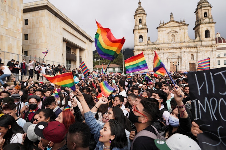 Multitud de personas portando banderas arcoíris