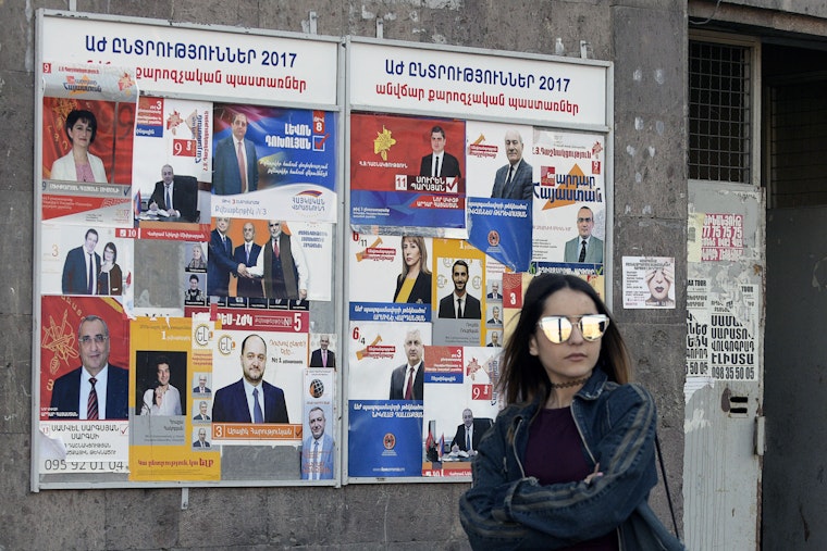 A woman walks past election posters in Yerevan, Armenia, on March 29, 2017. Photo credit: © Karen Minasyan/AFP/Getty A woman in sunglasses
