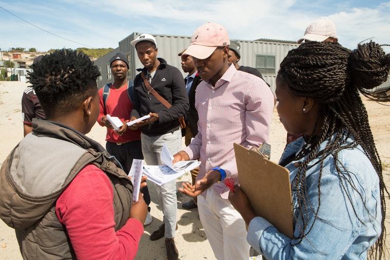 People standing in a circle in a settlement