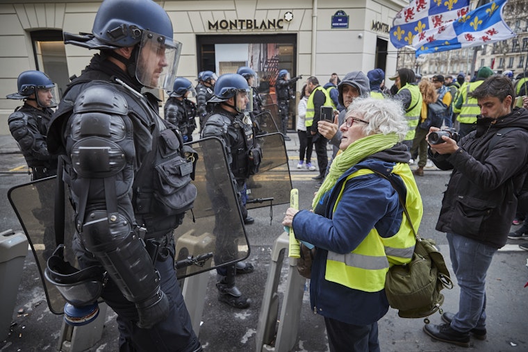 Un manifestant affronte un policier lors de manifestations près des Champs-Élysées, le 2 mars 2019, à Paris, France. © Kiran Ridley/Getty Images Un manifestant fait face à un agent de police