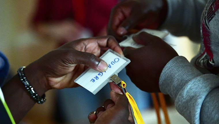 Refugee students receive name badges on the first day of classes at Central European University. Photo credit: © Attila Kisbenedek/AFP/Getty Hands holding badges