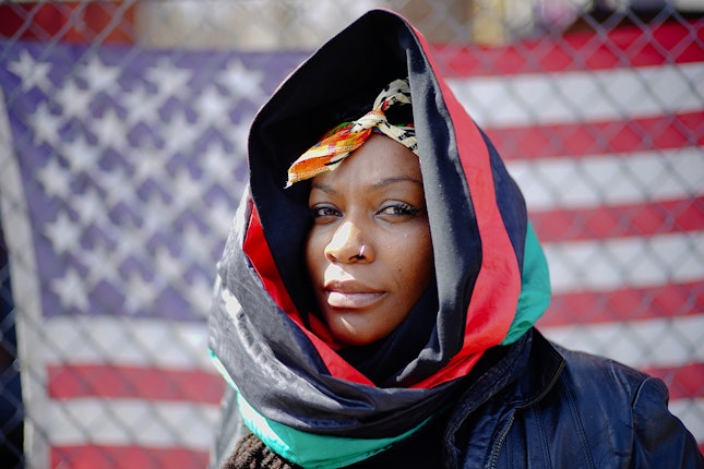 A woman in a scarf in front of an American flag