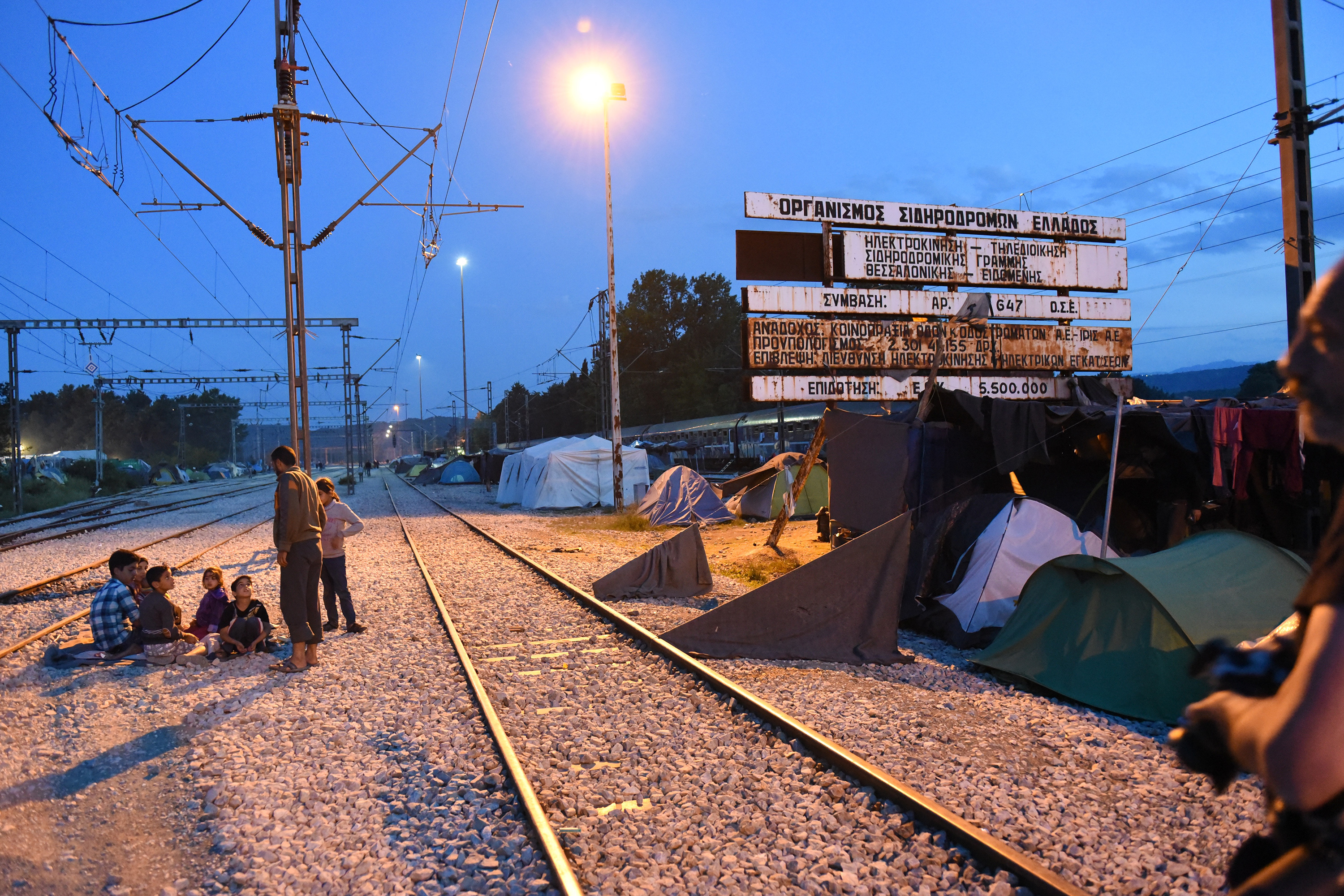A family sitting besides railway tracks at dusk