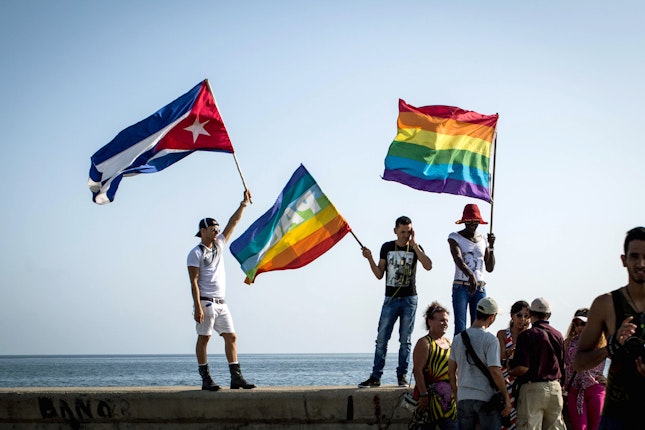 People waving Cuban and gay pride flags